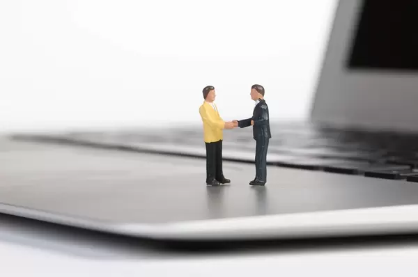 Businessman handshake on a laptop with white background