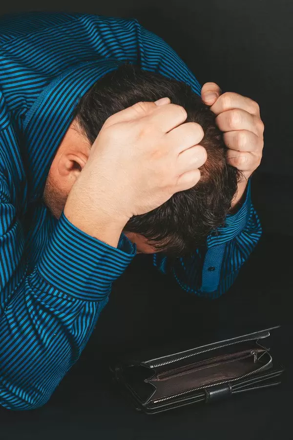 Businessman in a shirt with an empty wallet in despair. Concept of financial problems