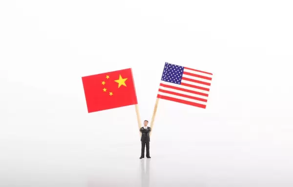 Businessman standing in front of flags of China and USA