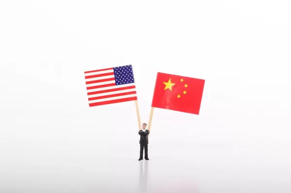 Businessman standing in front of flags of USA and China