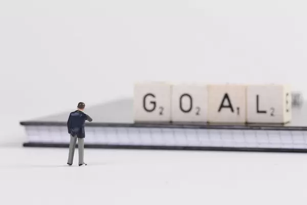 Businessman standing in front of Goal text