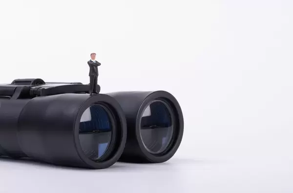 Businessman standing on a binoculars
