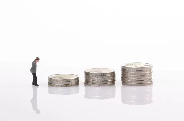 Businessman with coin stacks on white background
