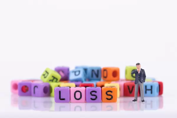 Businessman with colorful toy blocks with Loss text