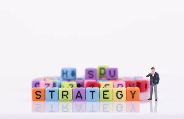 Businessman with colorful toy blocks with Strategy text