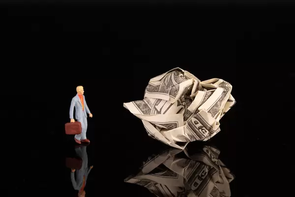 Businessman with crumpled money on black background