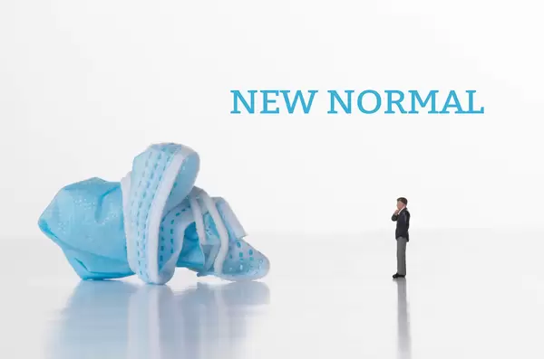 Businessman with medical face mask and New Normal text