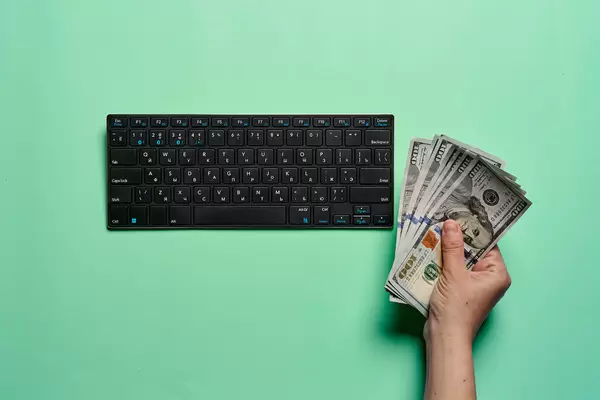 Businesswoman holding cash and using computer for e-commerce
