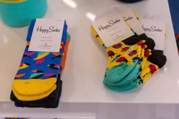 Buten Socken "Happy Socks" verpackt liegend auf einem weißen Tisch
