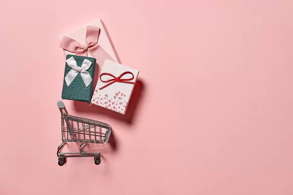 Buying gifts concept - present boxes in the shopping cart