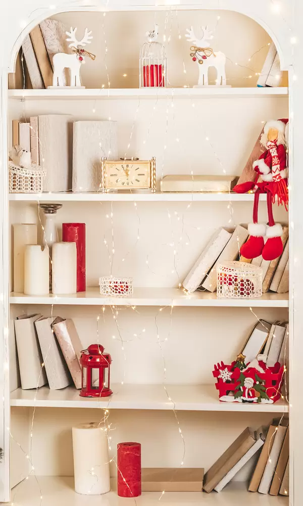 Cabinet shelves with books, candles and christmas decor