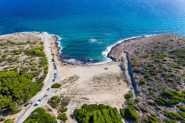 Cala Mitjana near Artà, Mallorca. Aerial view of sandy beach with very few people and cars