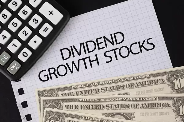 Calculator, money and Dividend Growth Stocks text on black table