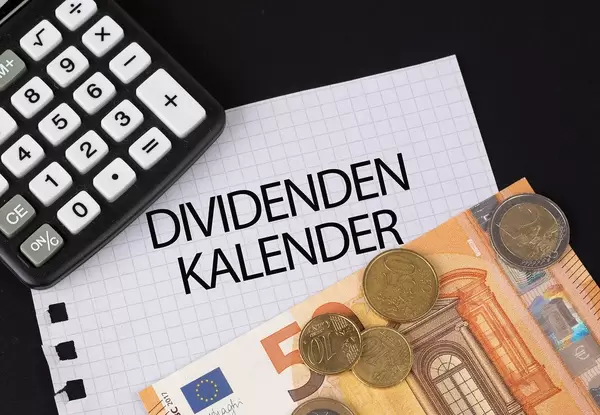 Calculator, money and Dividenden Kalender text on black table