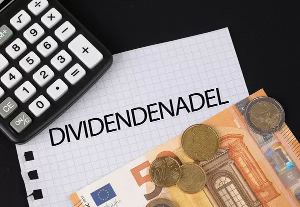 Calculator, money and Dividendenadel text on black table