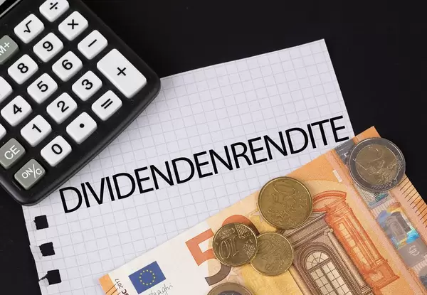 Calculator, money and Dividendenrendite text on black table