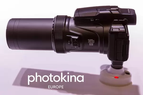 Camera with 125x optical zoom wide 4k next to picture Titel "photokina Europe"