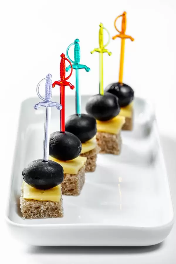 Canape dressed on swords with black olives and cheese