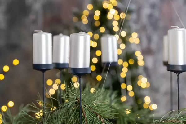 Candles on a blurred background of a christmas tree and glowing garlands