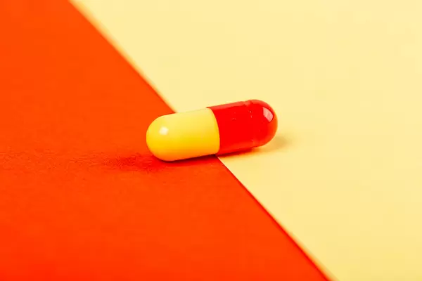 Capsule on a yellow-red background, close-up
