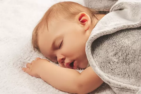 Carefree beautiful sleep of a little boy with open mouth