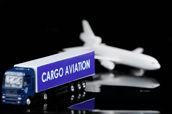 Cargo Aviation Lastwagen und Flugzeug im Hintergrund, mit Spiegelung auf schwarzer Oberfläche