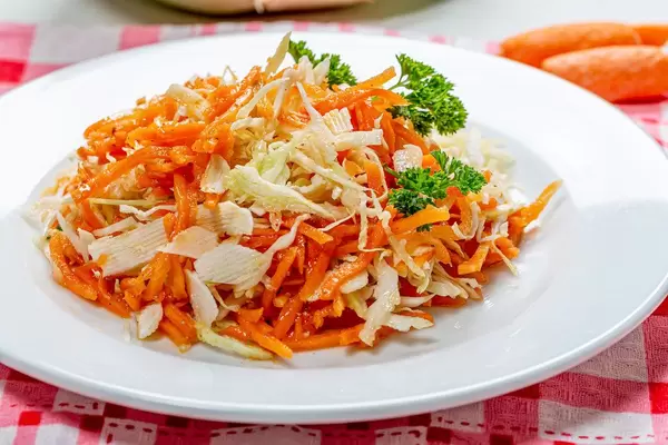 Carrot and cabbage salad on a white plate close-up. Healthy diet (Flip 2019)