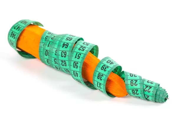 Carrots wrapped with measuring tape on white