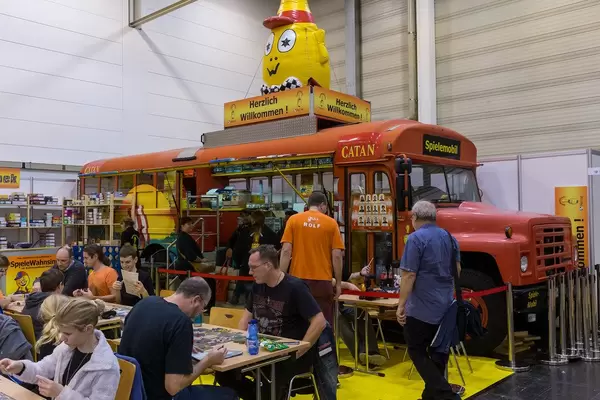 Catan Spielmobil Bus und Fans spielend davor