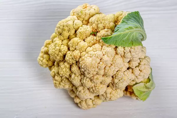 Cauliflower head on white wooden background