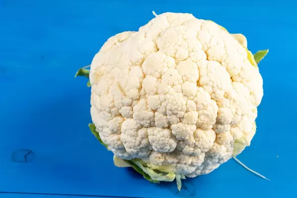 Cauliflower on the blye wooden board