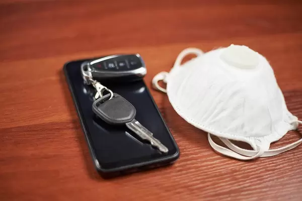 Cell phone, protective face mask and car keys. Must have items during coronavirus pandemic