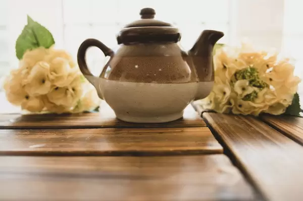 Ceramic brown teapot on a wooden surface (Flip 2019)