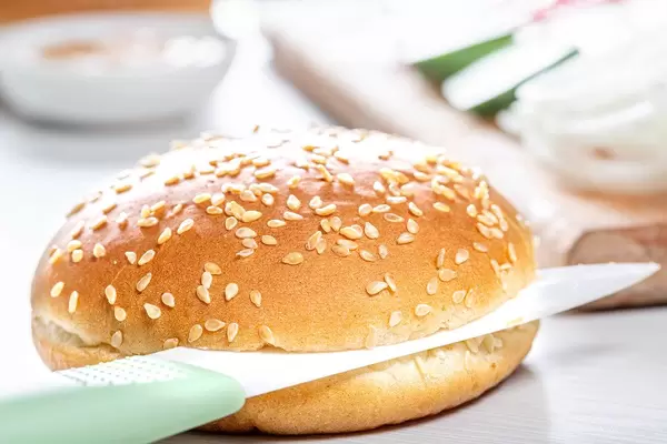 Ceramic knife cut the bun for the Burger in half