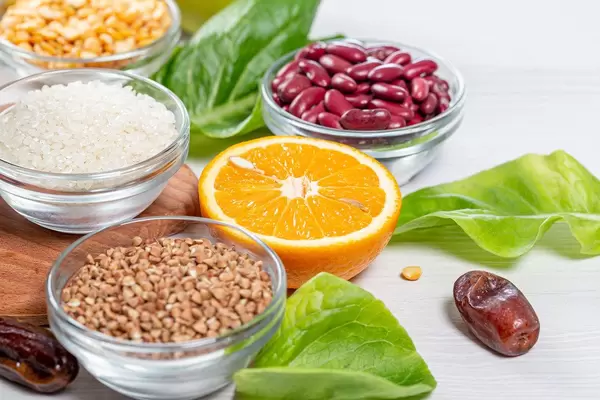 Cerealien-Römersalat, halbe, saftige Orange und einzelne Datteln: Konzeptbild für Zutaten einer gesunden Ernährung