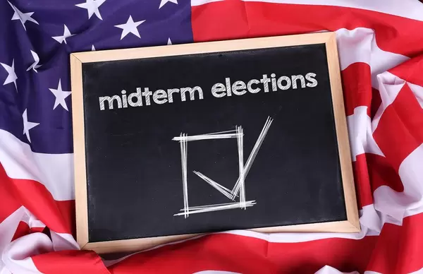 Chalkboard with Midterm elections text on American flag