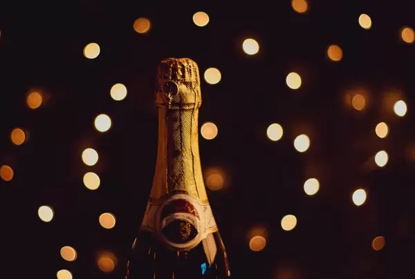 Champagnerflasche in festlicher Atmosphäre vor Lichtermeer im Hintergrund