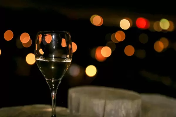 Champagnerglas zu Neujahr mit Bokeh-Lichtern auf dunklem Hintergrund