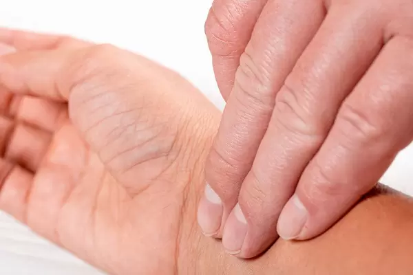 Checking pulse by hand on white background (Flip 2019)