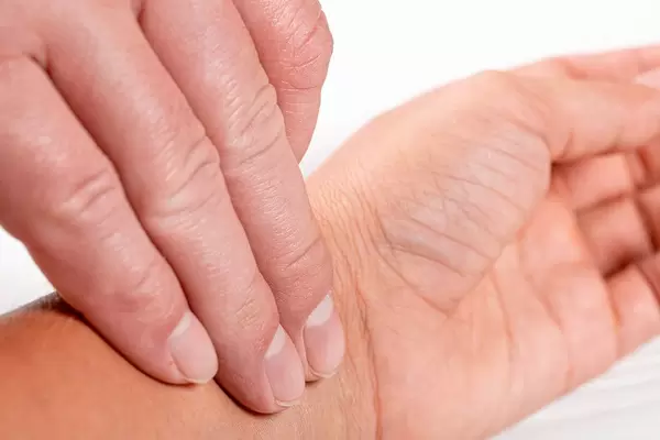 Checking pulse by hand on white background