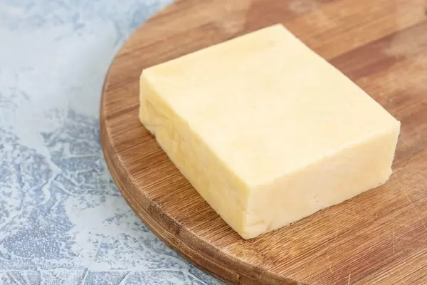 Cheddar Yellow Cheese on the kitchen wooden board