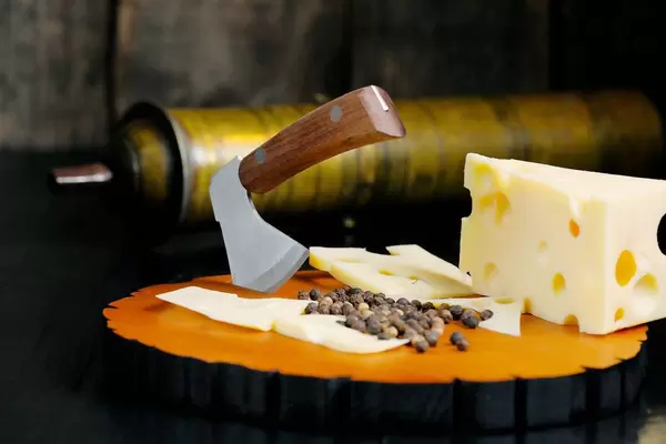 Cheese knife, peppercorns and Swiss cheese