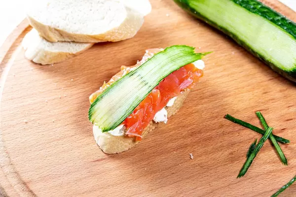 Cheese sandwich, red fish fillet and a piece of fresh cucumber