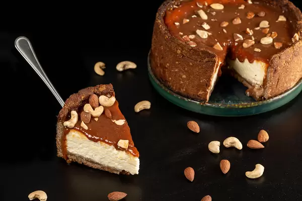 Cheesecake with condensed milk and nuts on a dark background