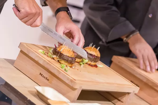 Chef cutting a hamburger into four pieces