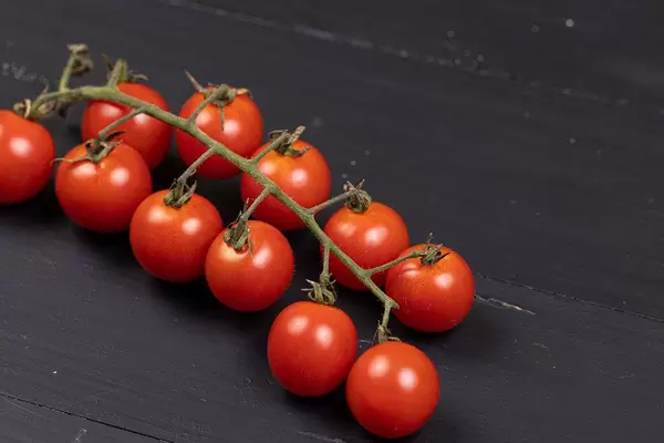 Cherry Tomatoes on the black wooden background