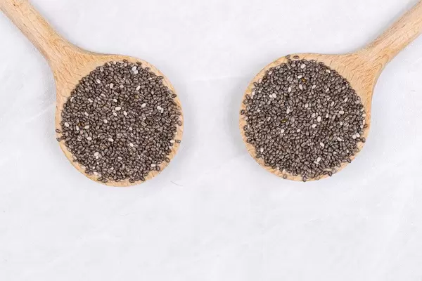 Chia Seeds on the two wooden spoons above white background