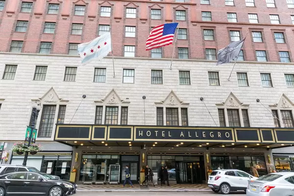 Chicago and US flags in the wind at the entrance to Kimpton Hotel Allegro: boutique hotel in Downtown Chicago