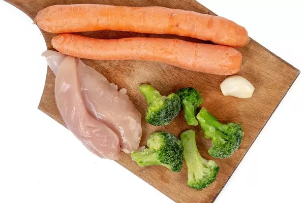 Chicken breasts with Carrots Broccoli and Garlic on the wooden board (Flip 2019)