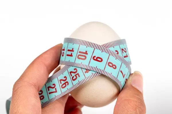 Chicken egg wrapped with measuring tape - diet food concept